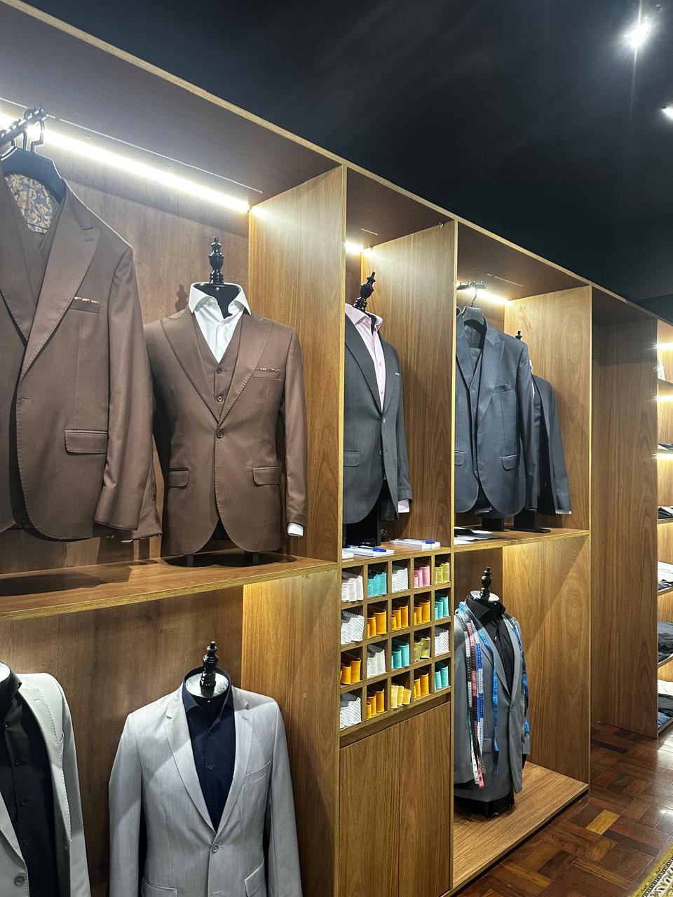 Parede de ternos masculinos sob medida no showroom da FL Alfaiataria em Pelotas